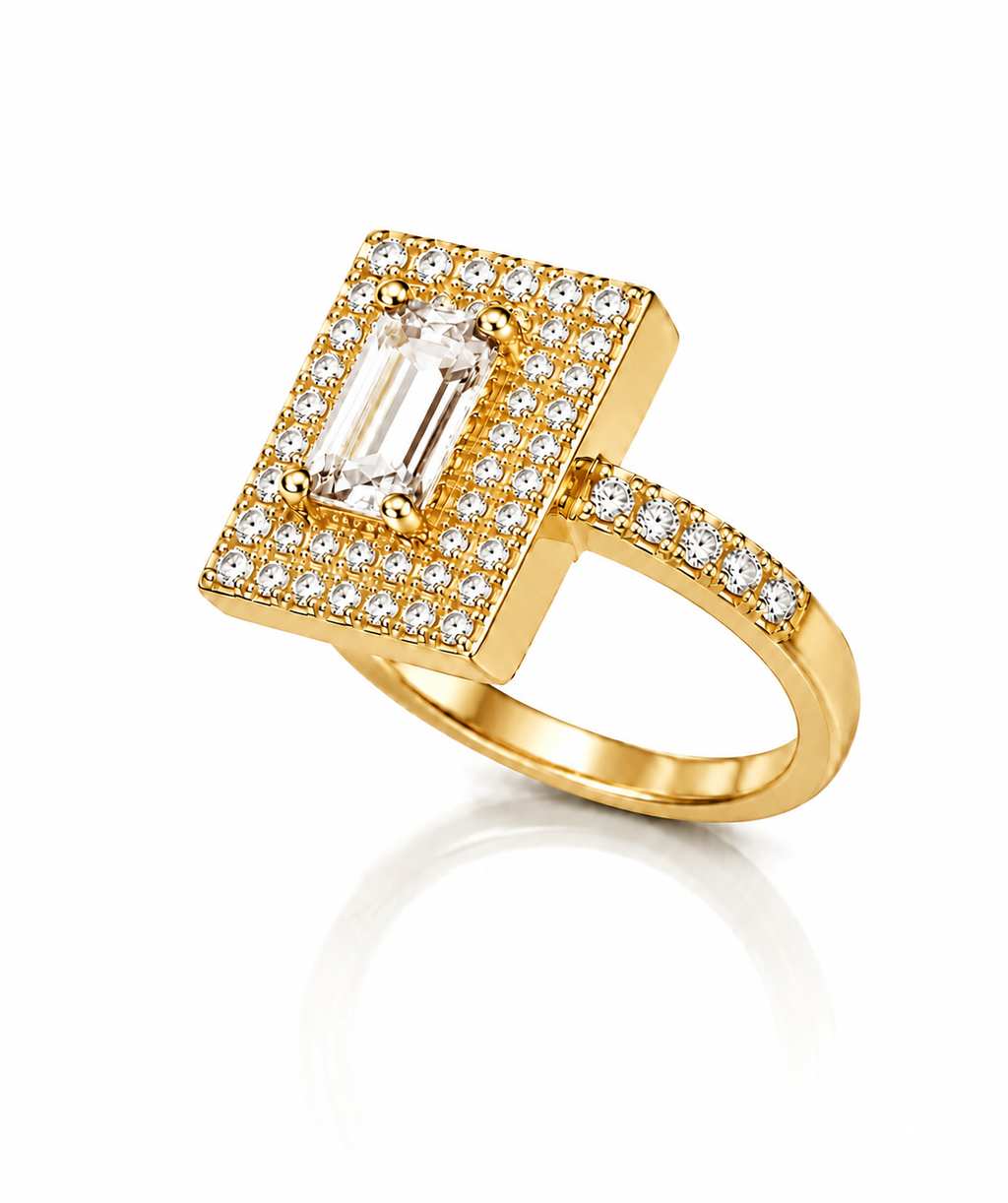 Anel dourado com pedra retangular transparente e aro com fileira de cristais