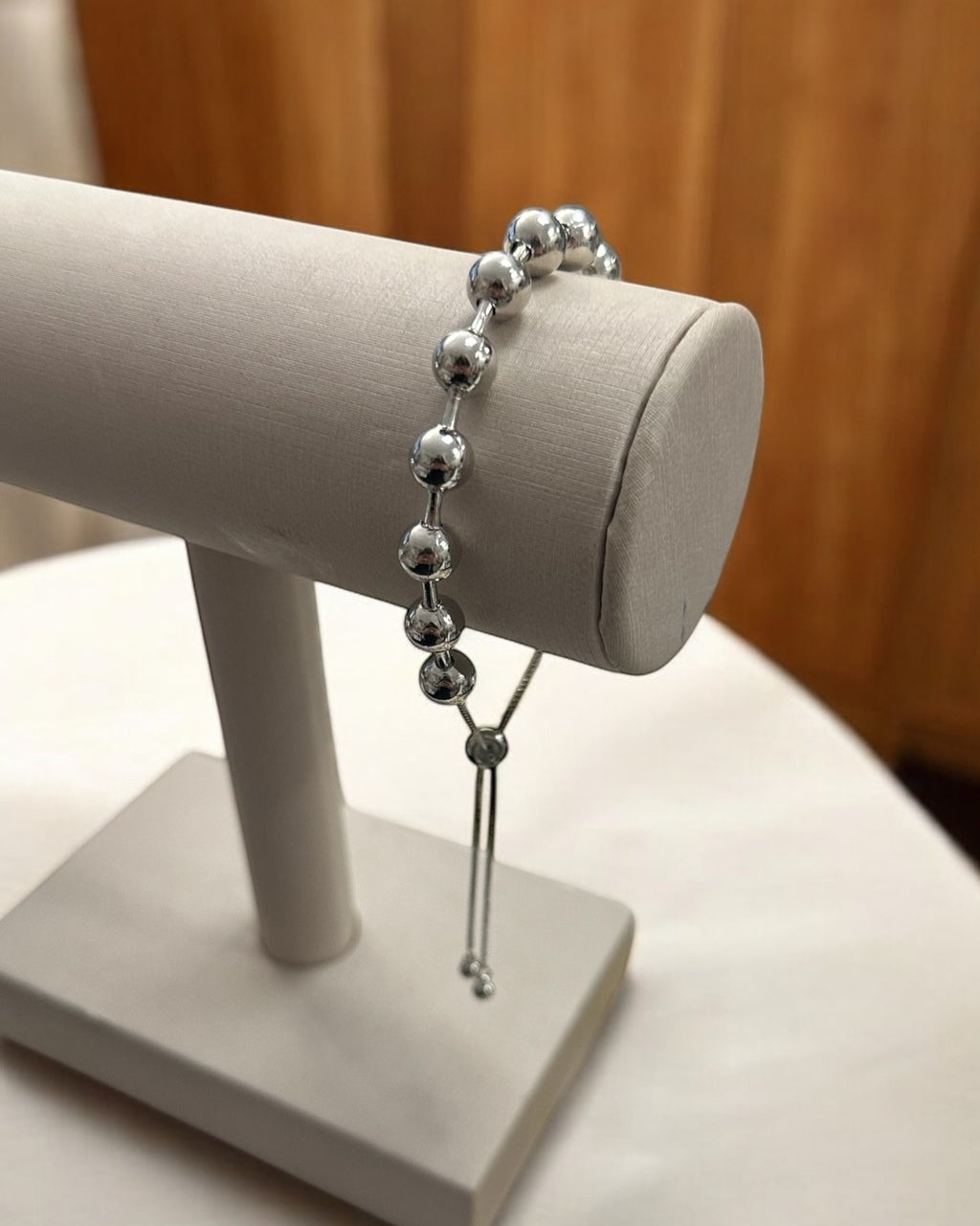 Pulseira Lia prateada com contas esféricas e pingente longo com acabamento em elos.