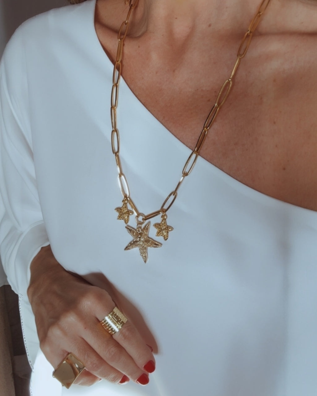Colar dourado com corrente de elos e pingentes de estrelas