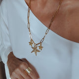 Colar dourado com corrente de elos e pingentes de estrelas