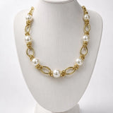 Colar dourado com pérolas brancas e elos ovais entrelaçados