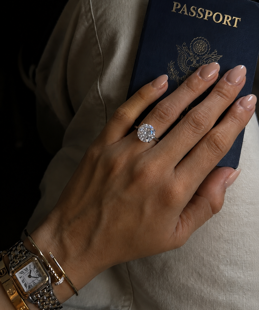 Anel dourado com pedra redonda e detalhes brilhantes, estilo solitário