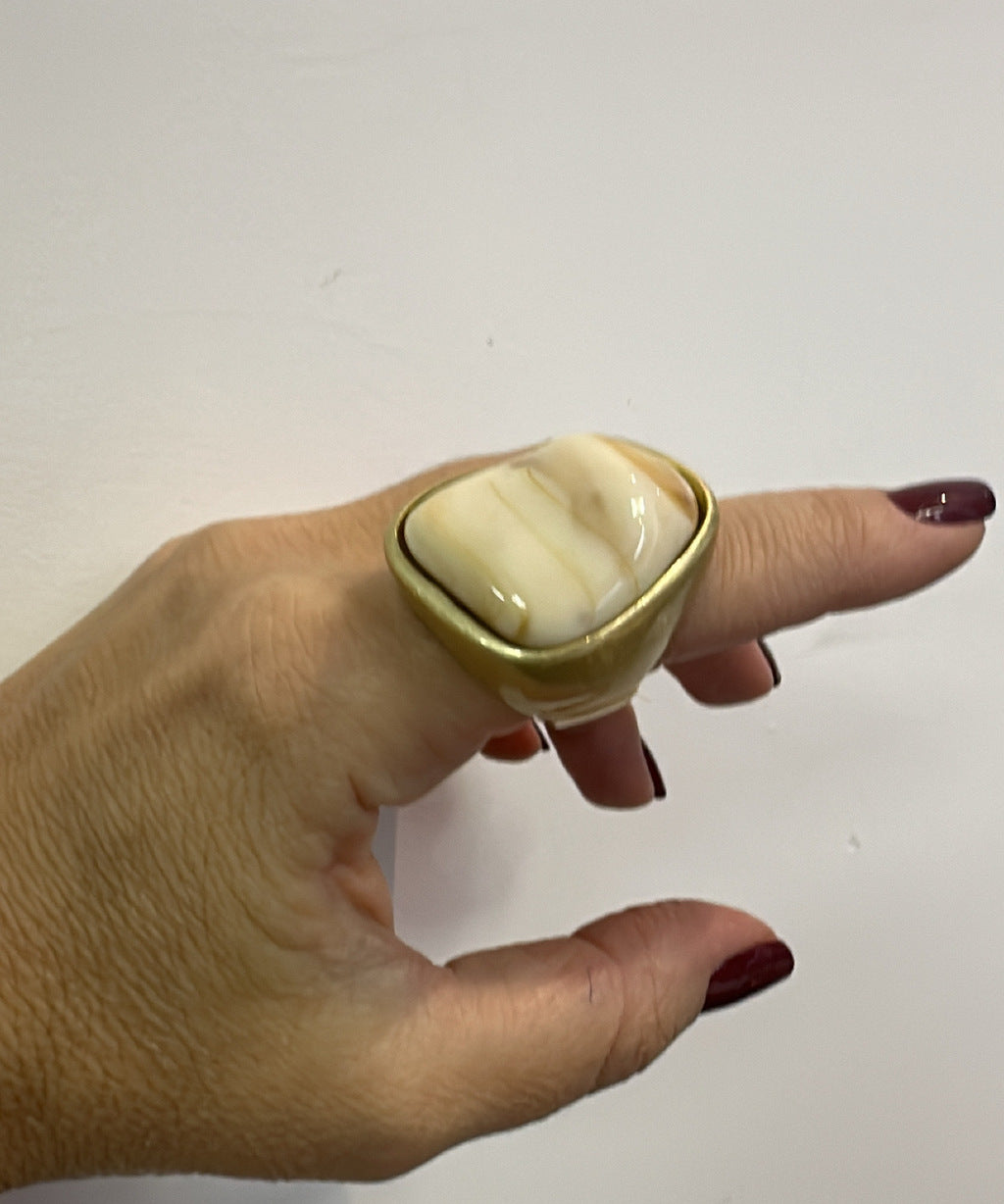 Anel com pedra oval nude em moldura dourada, design abaulado