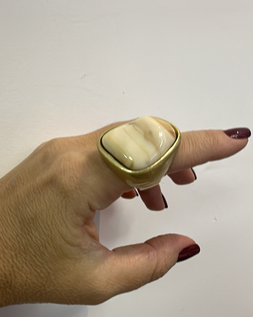 Anel com pedra oval nude em moldura dourada, design abaulado