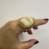 Anel com pedra oval nude em moldura dourada, design abaulado
