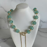 Colar Gloria Slim com contas verdes menta e fecho dourado, correntes longas.