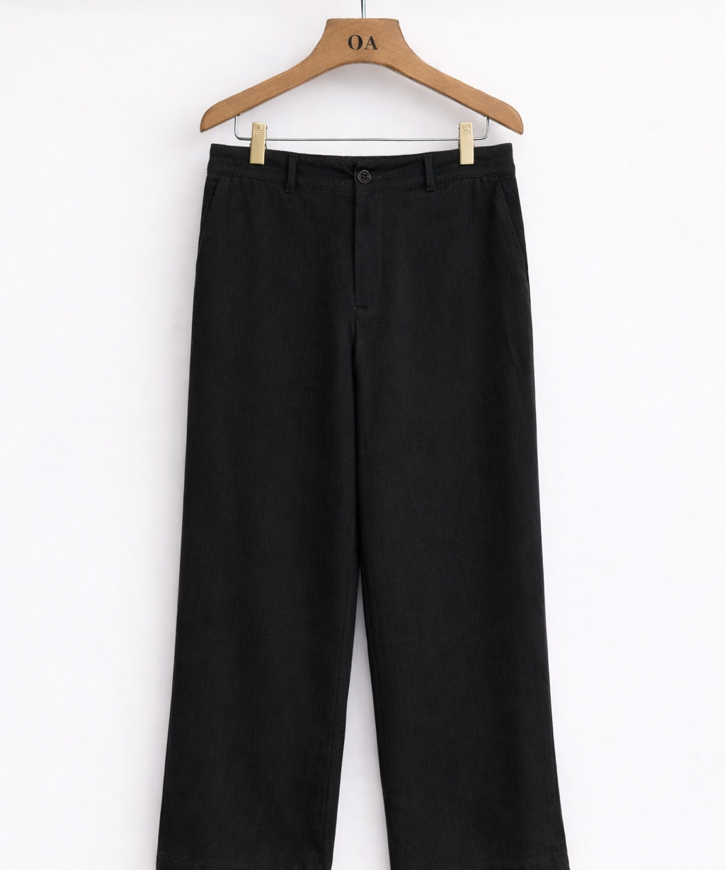Calça jeans preta ampla com cós estruturado e botão frontal, em cabide