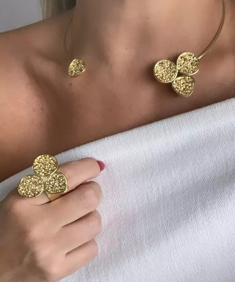 Anel dourado com três esferas texturizadas, formato de trevo