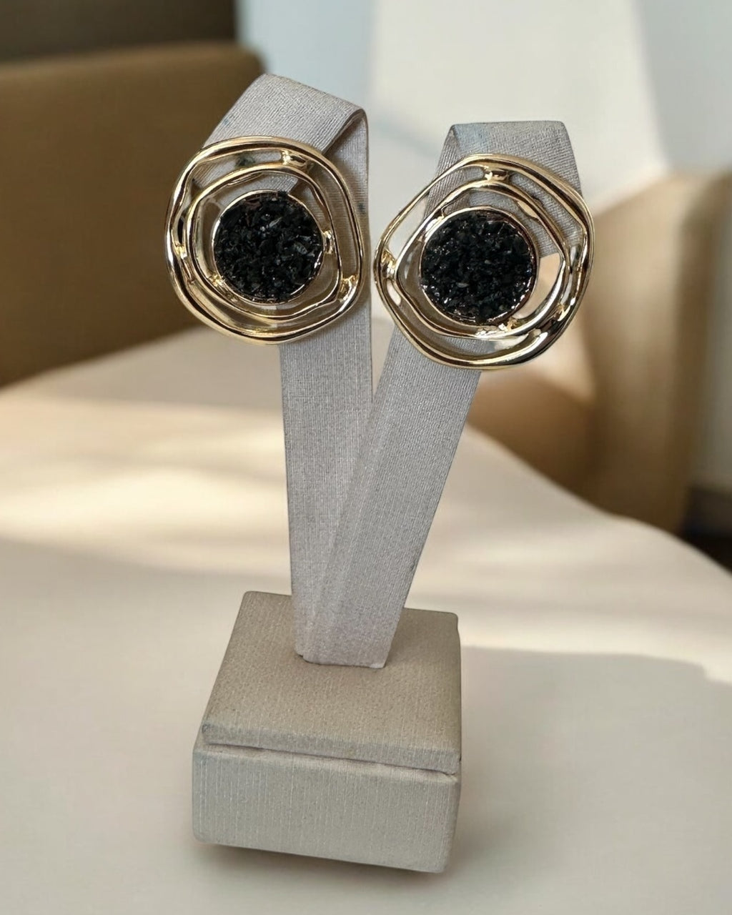 Par de brincos demi-uno com aro duplo dourado e detalhe central preto