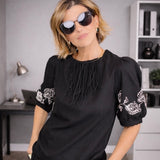 Blusa preta com bordado branco nas mangas e detalhe franzido na gola