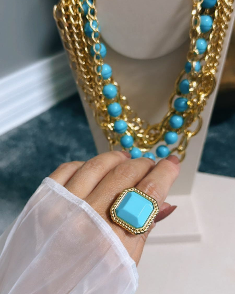 Anel Geneve azul com pedra quadrada azul em moldura dourada