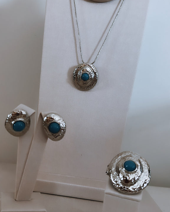 Conjunto de brinco e colar com pingente redondo azul e acabamento prateado