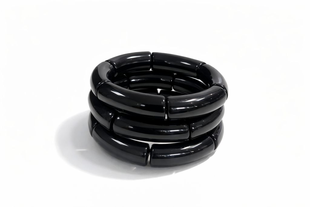 Trio de pulseiras de resina preta, três argolas empilhadas e brilhantes