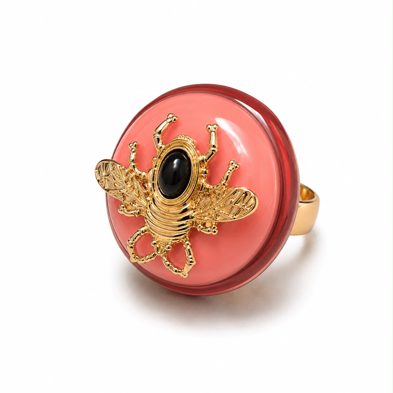 Anel Dacar coral com aro dourado e flor dourada sobre pedra oval preta
