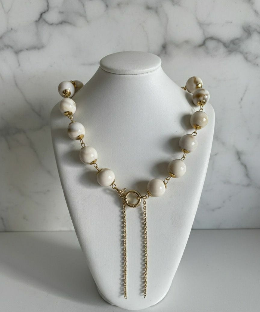Colar Gloria Slim com contas claras e fecho dourado em argola, duas correntes.