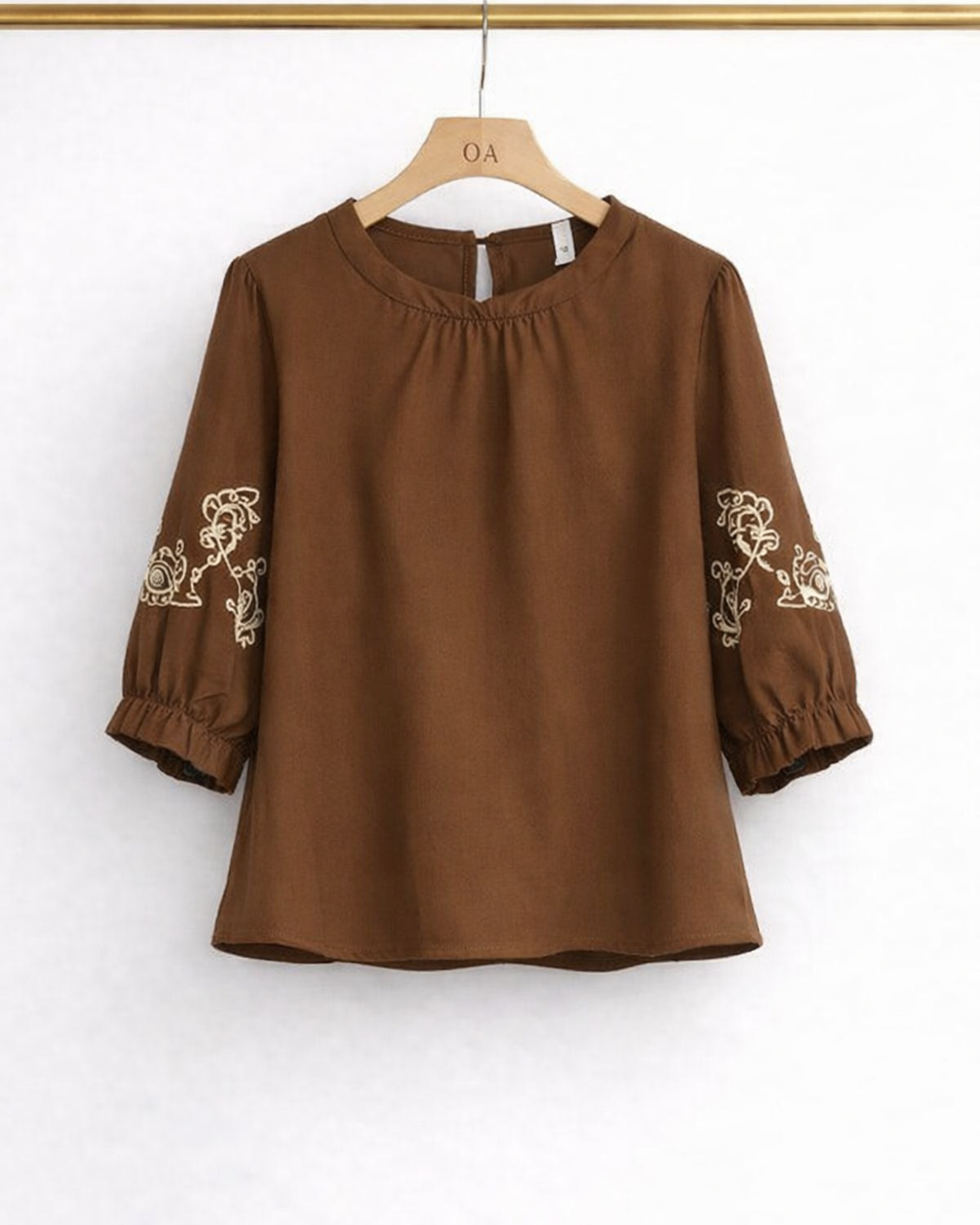 Blusa marrom com mangas 3/4 bufantes e bordado branco ornamental nas laterais