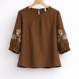 Blusa marrom com mangas 3/4 bufantes e bordado branco ornamental nas laterais