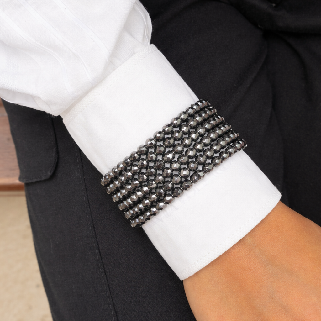 Pulseira de strass prateado, com três fileiras e fecho elástico, no punho