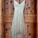 Vestido off-white de alças finas, decote V e bainha assimétrica com camadas