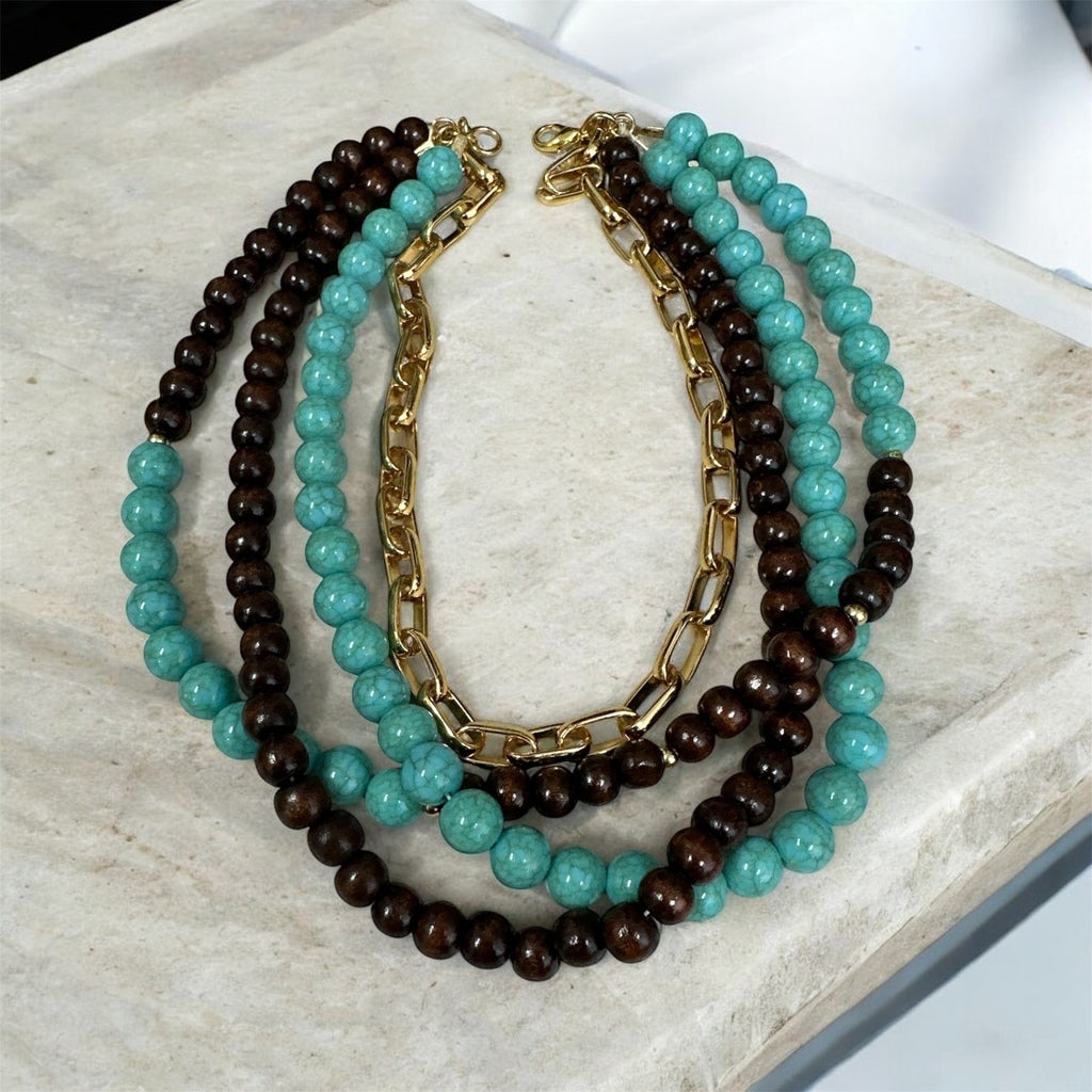 Colar maxi com contas azul-turquesa e marrom/pretas, várias voltas e fecho dourado