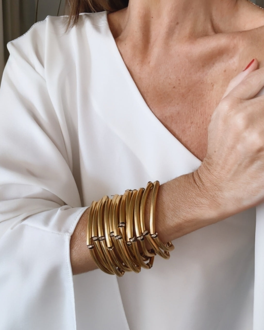 Pulseira dourada de braceletes múltiplos, com detalhes em tiras e elos