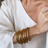 Pulseira dourada de braceletes múltiplos, com detalhes em tiras e elos