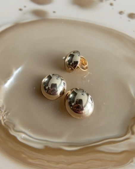 Conjunto de brincos esféricos metalizados, dourado e prateado, com superfície lisa