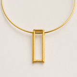 Detalhe do colar dourado com corrente e pingente retangular vazado