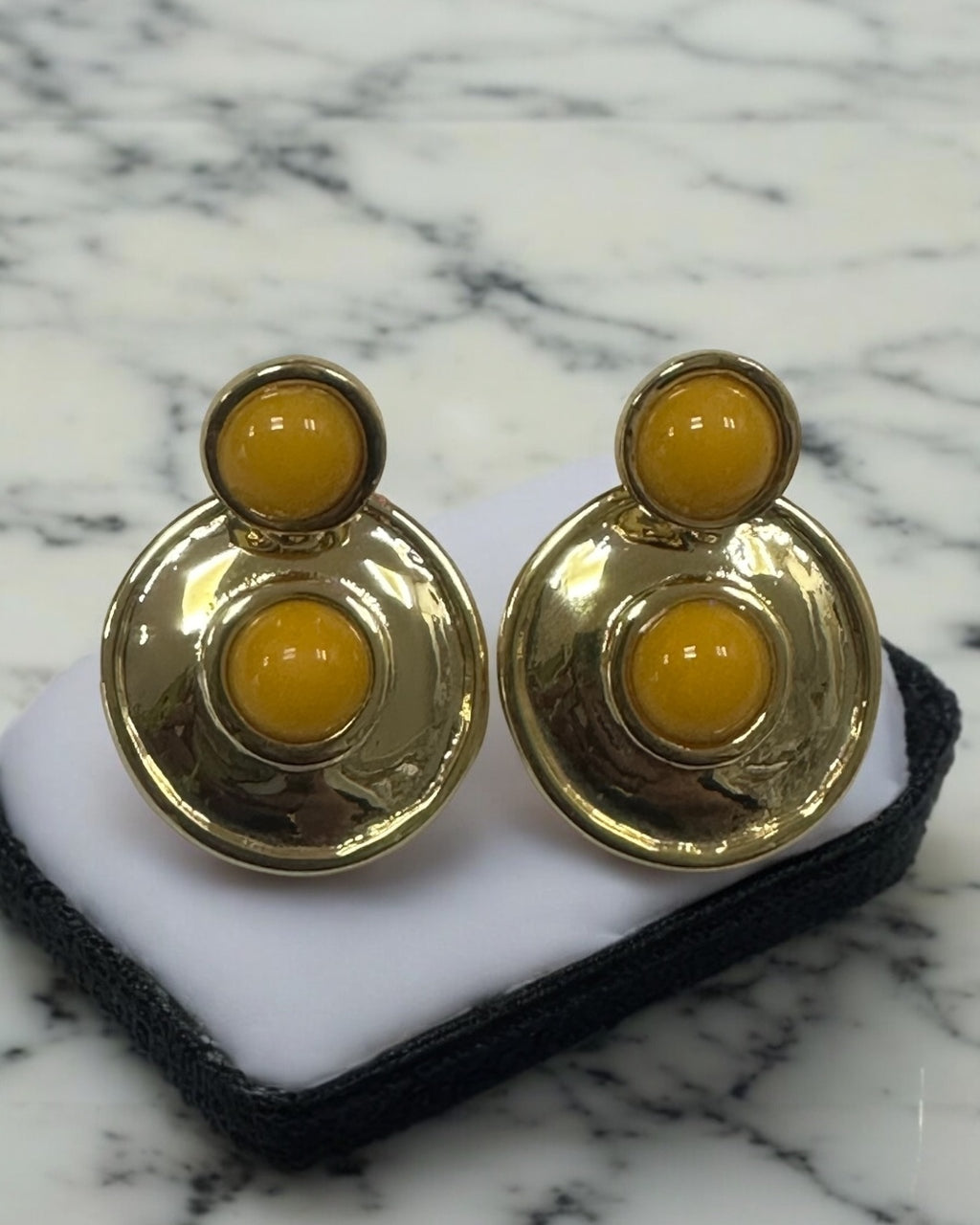 Brinco dourado com três pedras redondas amarelas