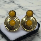 Brinco dourado com três pedras redondas amarelas