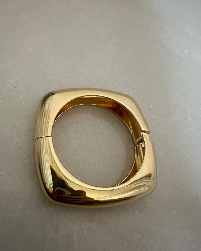 Pulseira Olivia Gold dourada com aro quadrado e fecho de encaixe, acabamento polido.