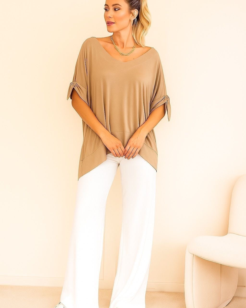 Blusa bege ampla com decote em V e mangas amplas presas nas laterais