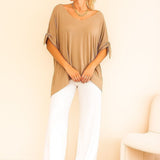 Blusa bege ampla com decote em V e mangas amplas presas nas laterais