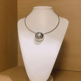 Colar prateado com pingente circular e esfera refletiva