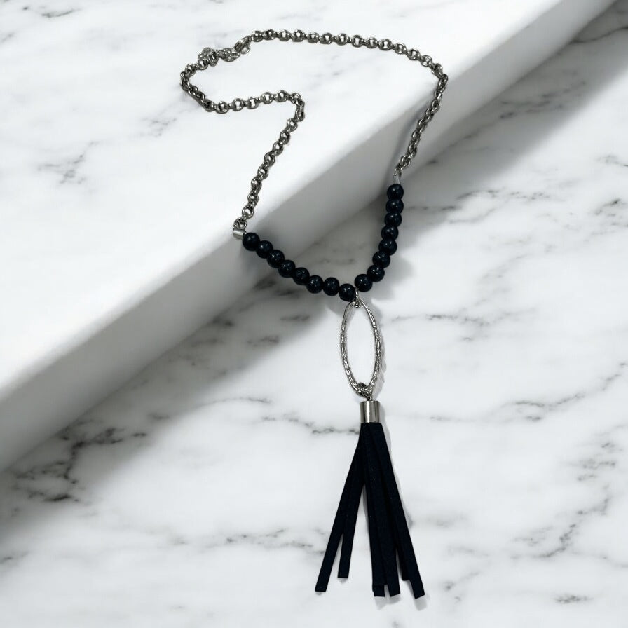 Colar boho com corrente prateada, miçangas escuras e pingente com franjas pretas