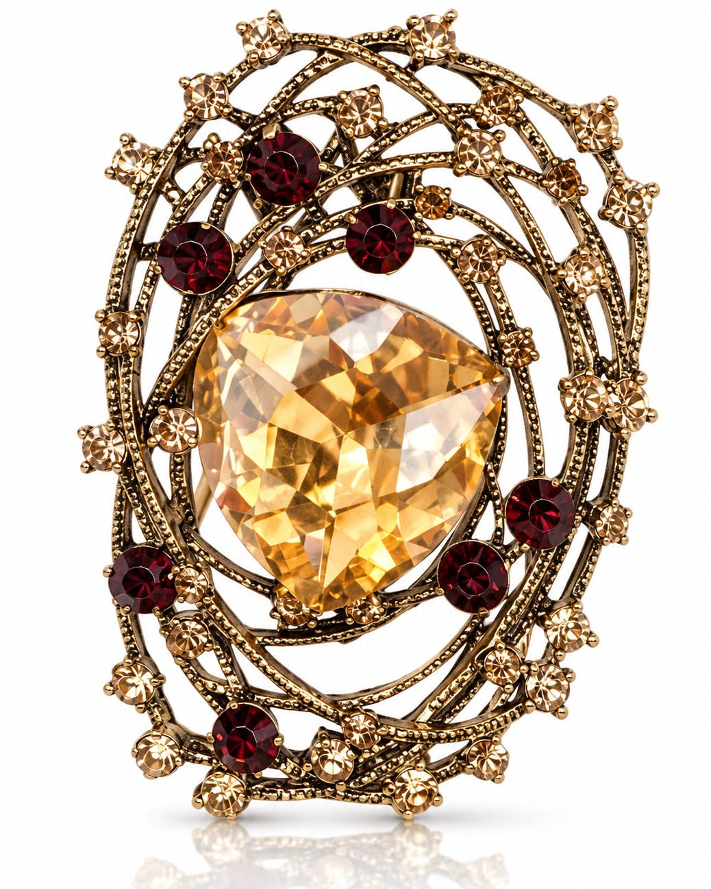 Broche metal dourado com pedra oval amarela e cristais vermelhos ao redor