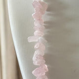 Pulseira de quartzo rosa com contas irregulares e fecho dourado em corrente.