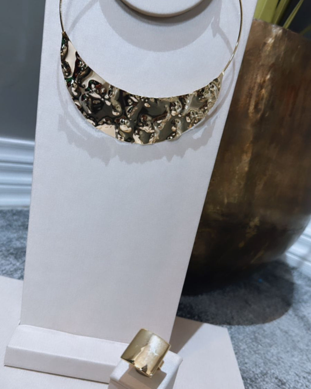 Colar dourado em camadas com peça semicircular texturizada e pingentes pendentes