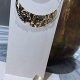Colar dourado em camadas com peça semicircular texturizada e pingentes pendentes