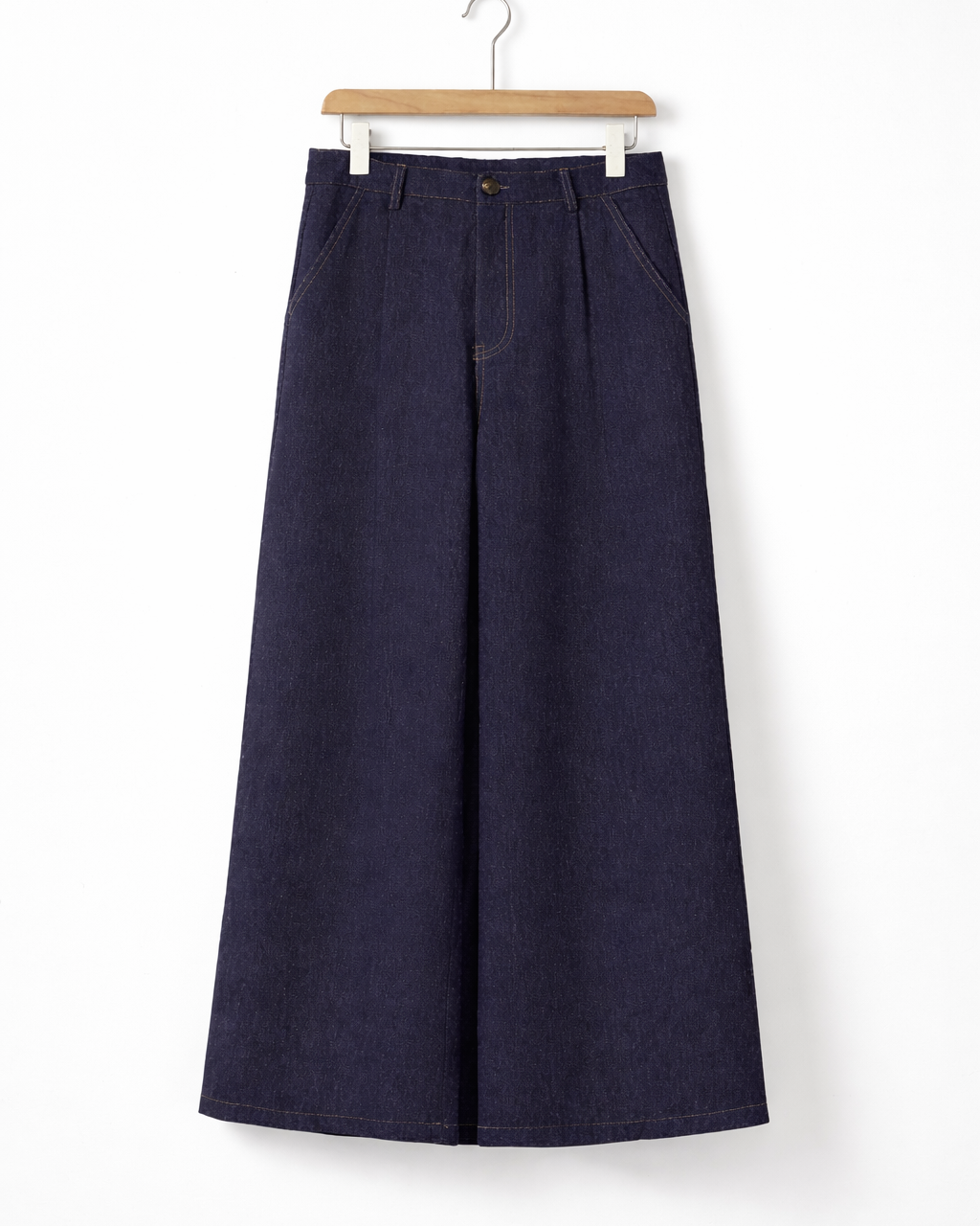 Calça jeans azul escuro ampla, vista frontal, cintura com passantes e detalhe do botão