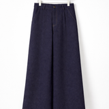 Calça jeans azul escuro ampla, vista frontal, cintura com passantes e detalhe do botão