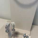 Par de brincos prateados com detalhe oval e pedra brilhante