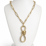 Colar dourado com corrente de elos e pingente oval com nó