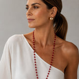 Colar Ana Julia de cristais vermelhos, usado em ombro com vestido branco
