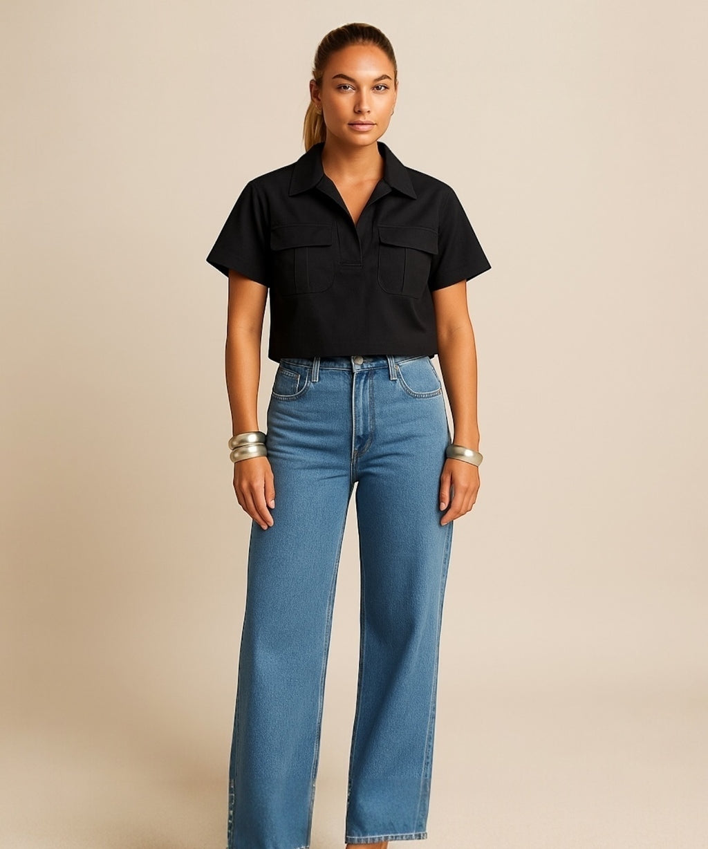 Blusa preta de botões, gola polo e mangas curtas, com dois bolsos frontais