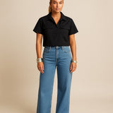 Blusa preta de botões, gola polo e mangas curtas, com dois bolsos frontais