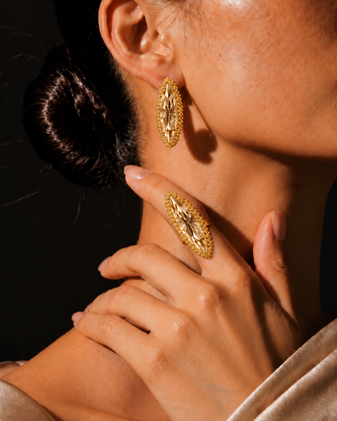 Anel Canoa dourado com pedra clara facetada e borda de pequenas esferas