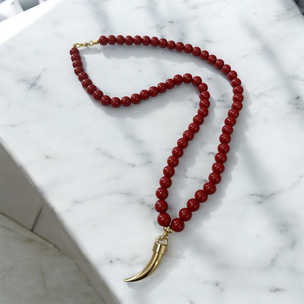 Colar de contas vermelho escuro com pingente de chifre dourado