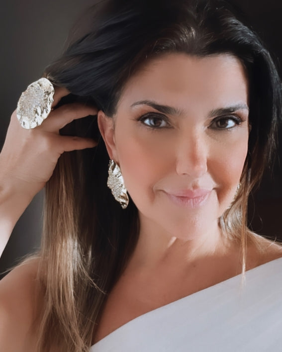 Brinco dourado pendente com textura acetinada, detalhe em formato irregular