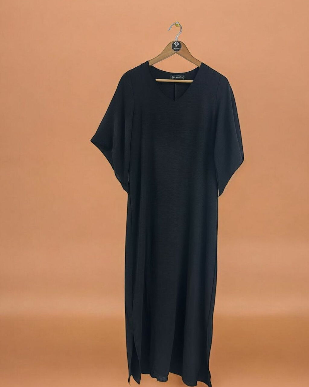 Vestido longo preto com decote V e mangas amplas, visual fluido.
